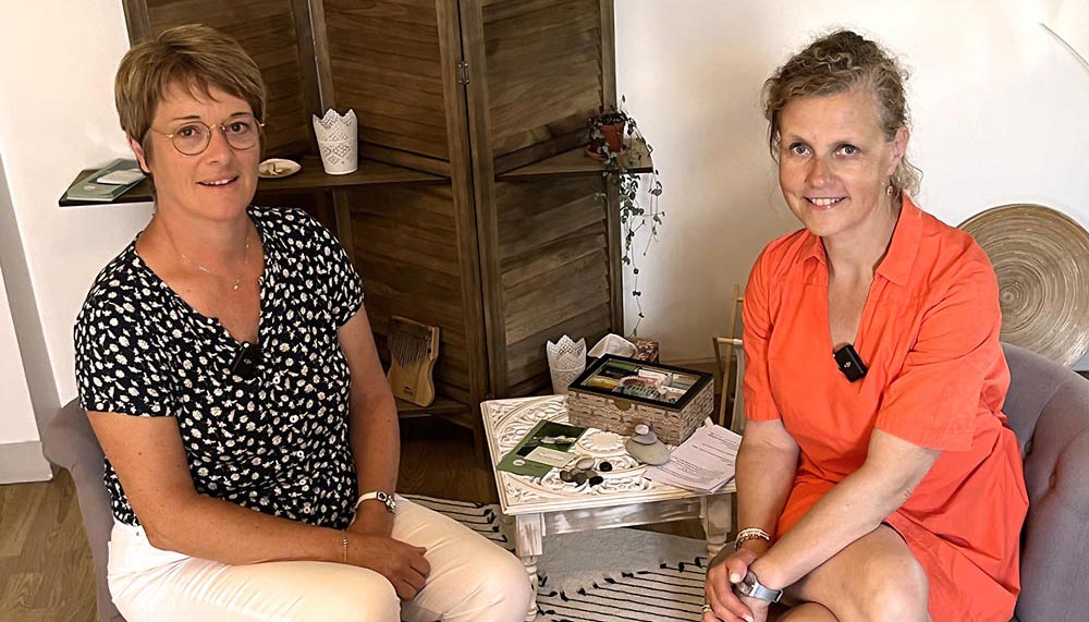 Béa, fondatrice de Femmes en Harmonie, en discussion avec Laurence Voisin, instructrice certifiée en méditation de pleine conscience. Assises dans un cadre accueillant, entourées de décorations naturelles et d’objets apaisants, elles échangent sur les bienfaits de la pleine conscience, des techniques de base et des conseils pour intégrer cette pratique dans la vie quotidienne afin de mieux gérer le stress et améliorer le bien-être.