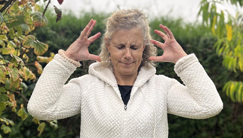 Béa, fondatrice de Femmes en Harmonie, dans son jardin illustrant les premiers signes de la ménopause avec une expression de stress et de tension, et représentant les défis émotionnels et physiques liés à cette étape.