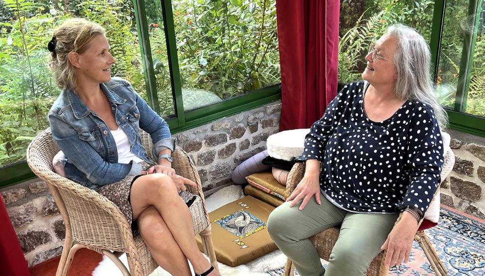 Béa, fondatrice de Femmes en Harmonie, interviewant Corinne Thoiron, hypnothérapeute, dans le cadre chaleureux d'une véranda entourée de verdure. Cette rencontre met en lumière les bienfaits de l’hypnose pour soulager le stress, améliorer le bien-être émotionnel et retrouver un équilibre intérieur.