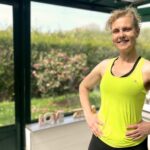 Béa, fondatrice de Femmes en Harmonie, en tenue de sport dans sa véranda, prête à guider sur des exercices pour brûler les graisses. Cette séance te permettra de tonifier ton corps, relancer ton métabolisme et retrouver de l’énergie après 50 ans.