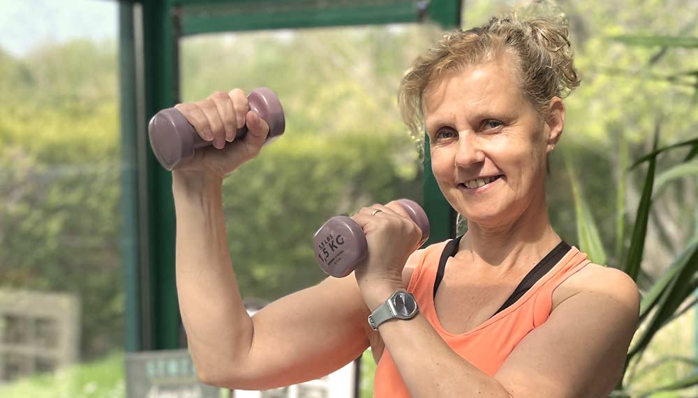 Béa, fondatrice de Femmes en Harmonie, en pleine séance de musculation pour les femmes après 50 ans avec des haltères légers.